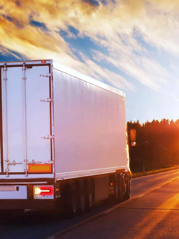 Camion de transport de marchandises circulant sur la route.